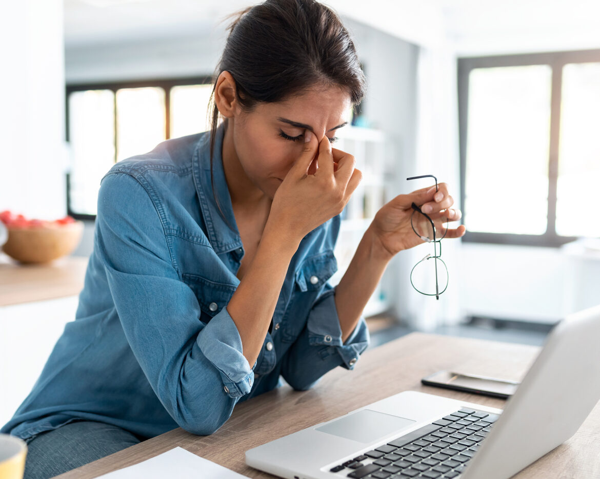 Stressed business woman working from home on laptop looking worr
