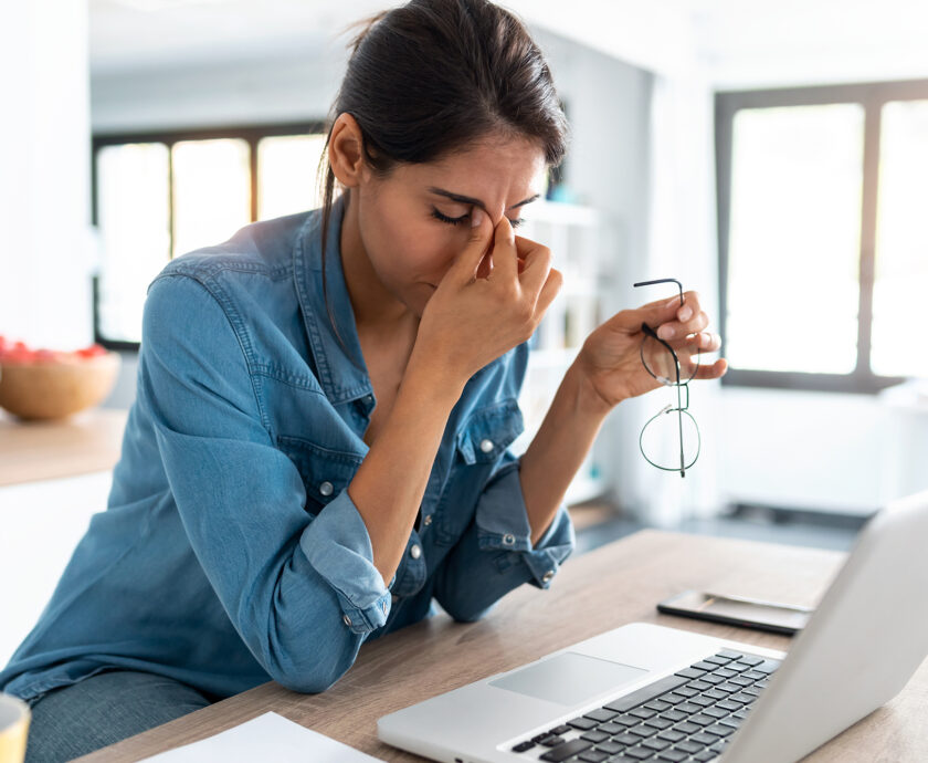 Stressed business woman working from home on laptop looking worr