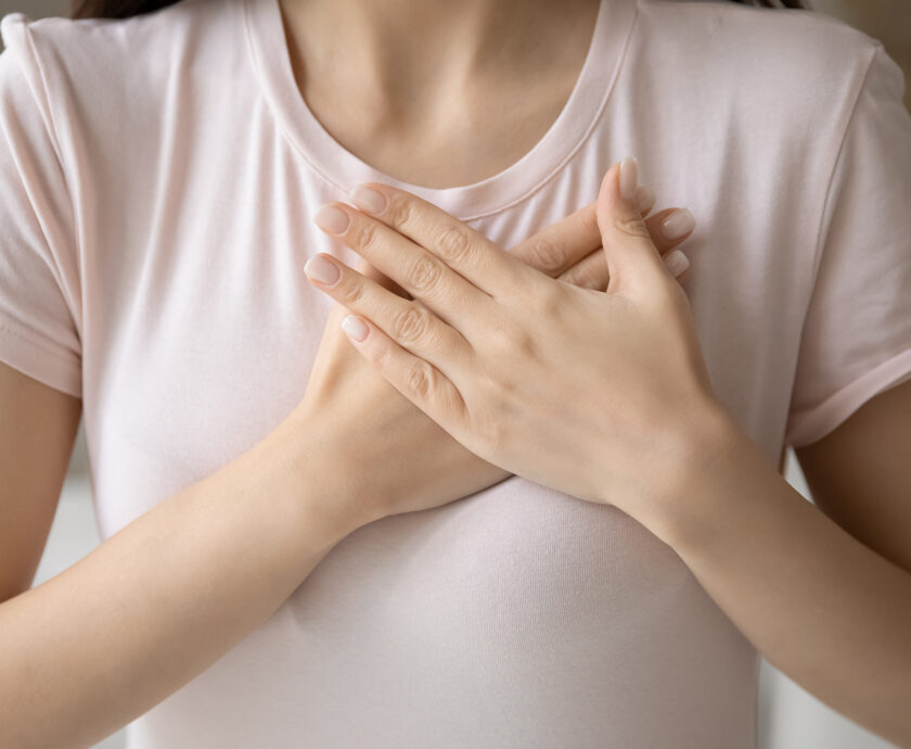 Grateful young woman applying hands on chest, expressing love
